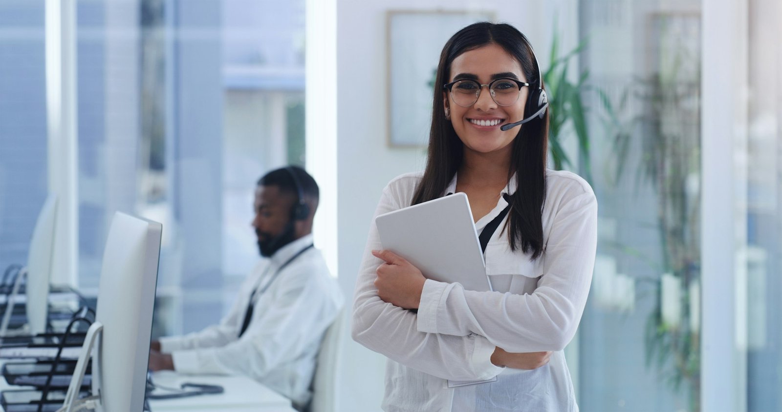 portrait of a young businesswoman wearing a headset and holding a digital tablet in an office.jpg