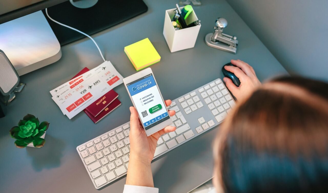 woman in a travel agency booking a trip looking at the covid passport.jpg